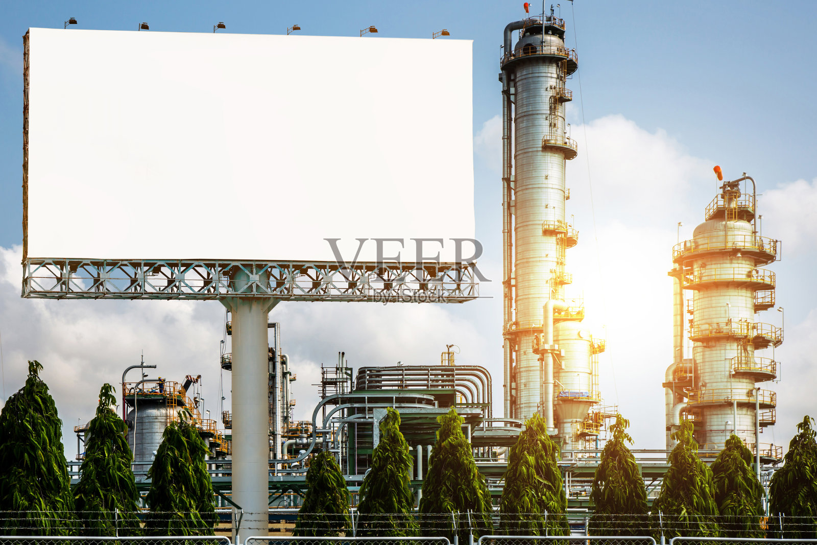空白广告牌与炼油厂,燃料石油工业工厂日落阳光-可以展示或蒙太奇产品或业务的广告。照片摄影